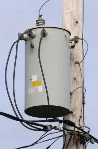 Typical US pole-mounted single-phase distribution transformer on a utility pole
